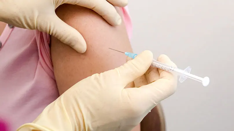 Patient erhält Impfung in den Oberarm