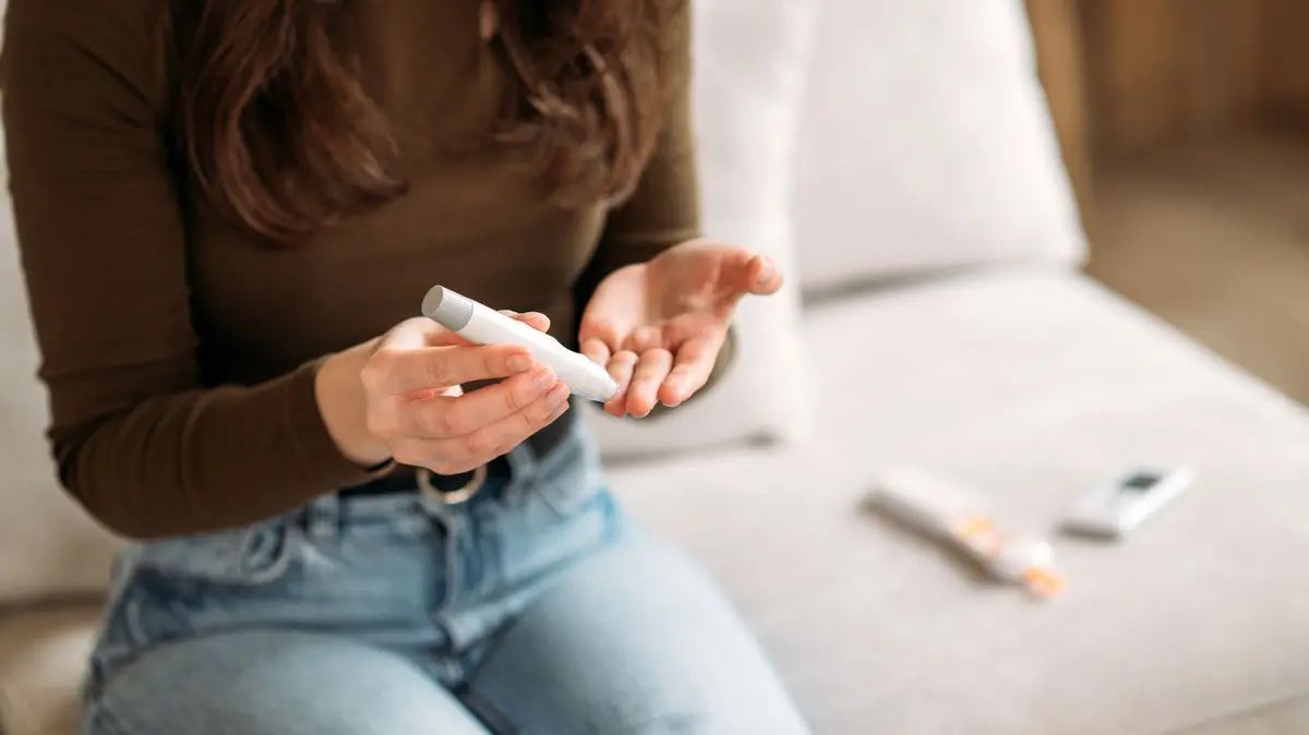 FRau misst ihren Blutzucker mittels Pen und Teststreifen