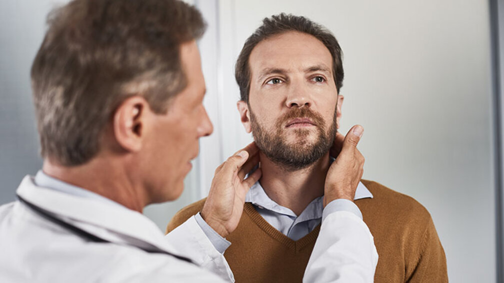 Arut untersucht Lympknoten am Hals eines Mannes