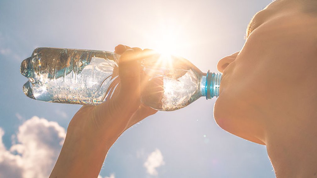 junge Frau trinkt aus Wasserflasche