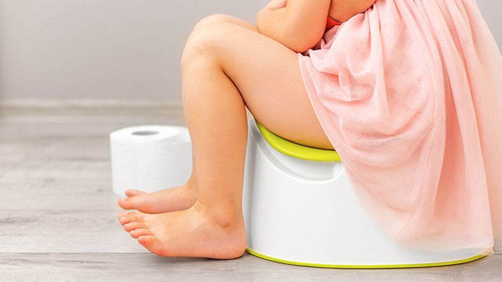 Kleines Mädchen auf Toilettentopf