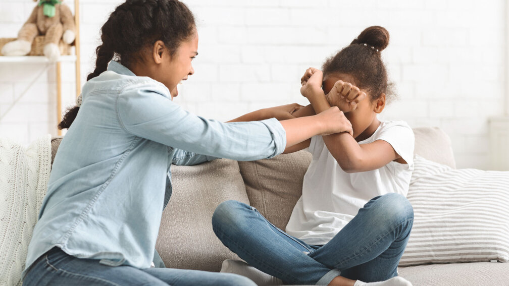 zwei jugendliche Mädchen sitzen auf der Couch und streiten sich