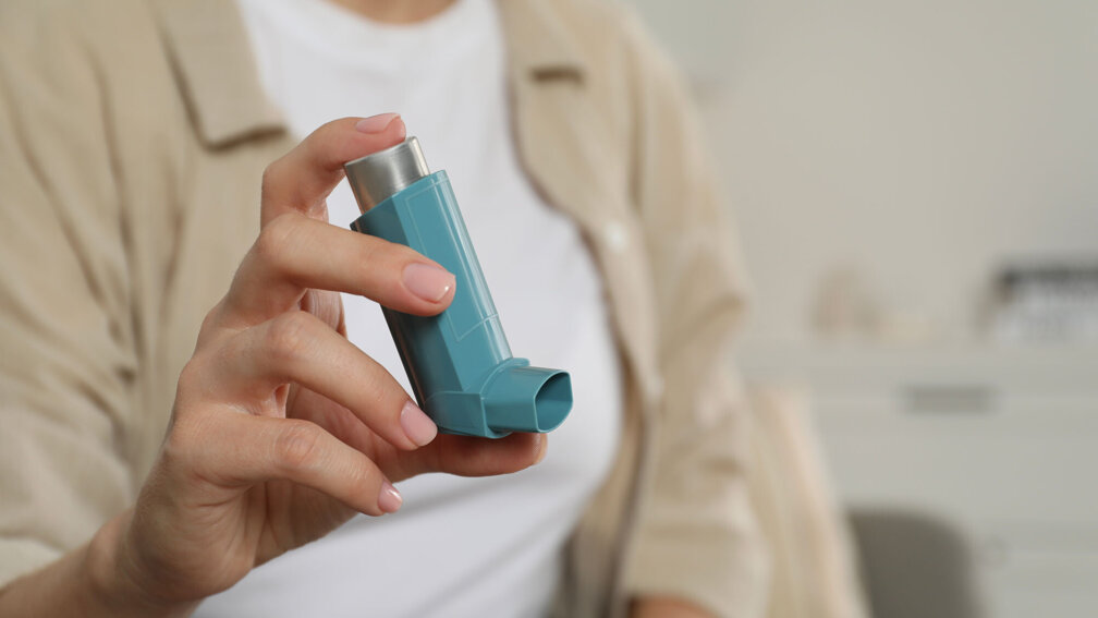 Frau hält ein Dosieraerosol in der Hand