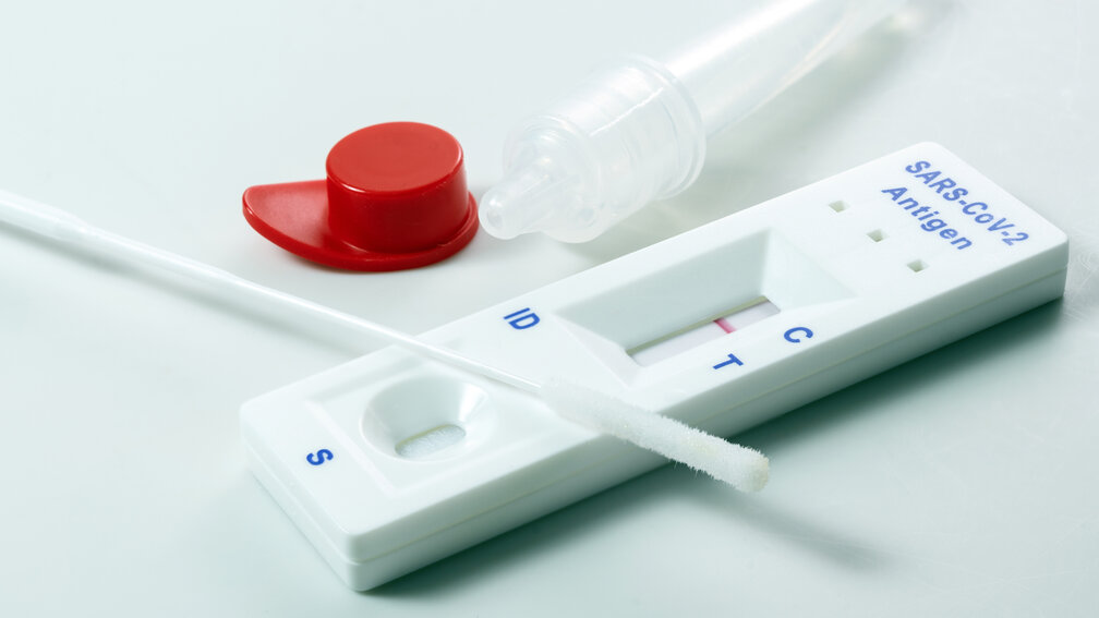 Negativer Coronatest neben Teströhrchen