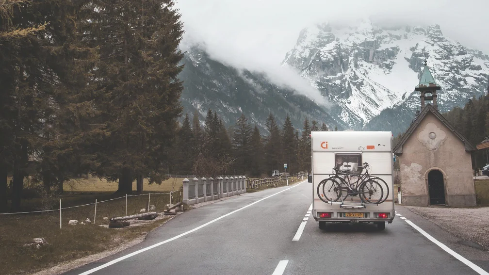 Wohnmobil fährt Richtung schneebedeckter Berge