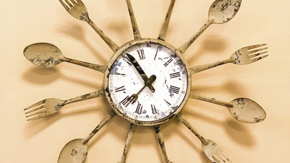 Wanduhr an der ringsum Messer, Gabeln und Löffel befestigt sind 