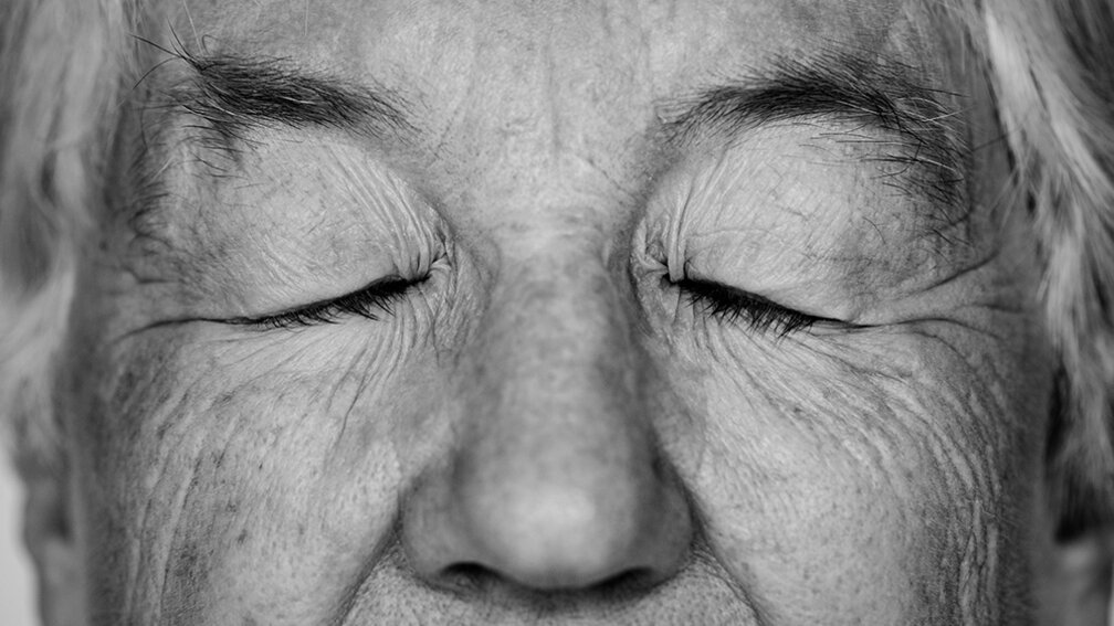 schwarz-weiß Bild vom Gesicht einer Senioren, Augen sind zu