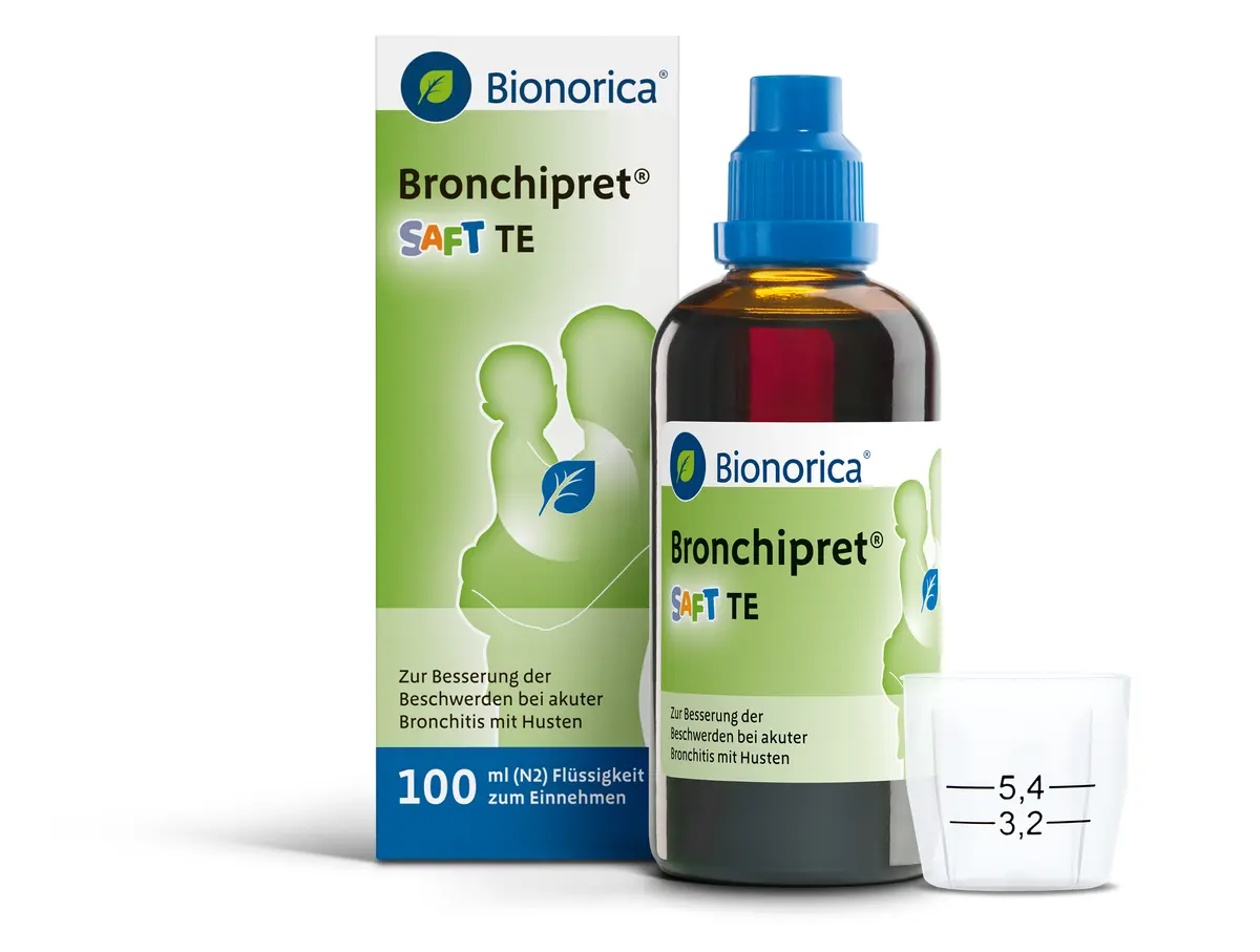 Bronchipret Saft TE ist mit brauner Glasflasche mittig neben der Leerschachtel links und dem Dossierbecher rechts davon, zu sehen.