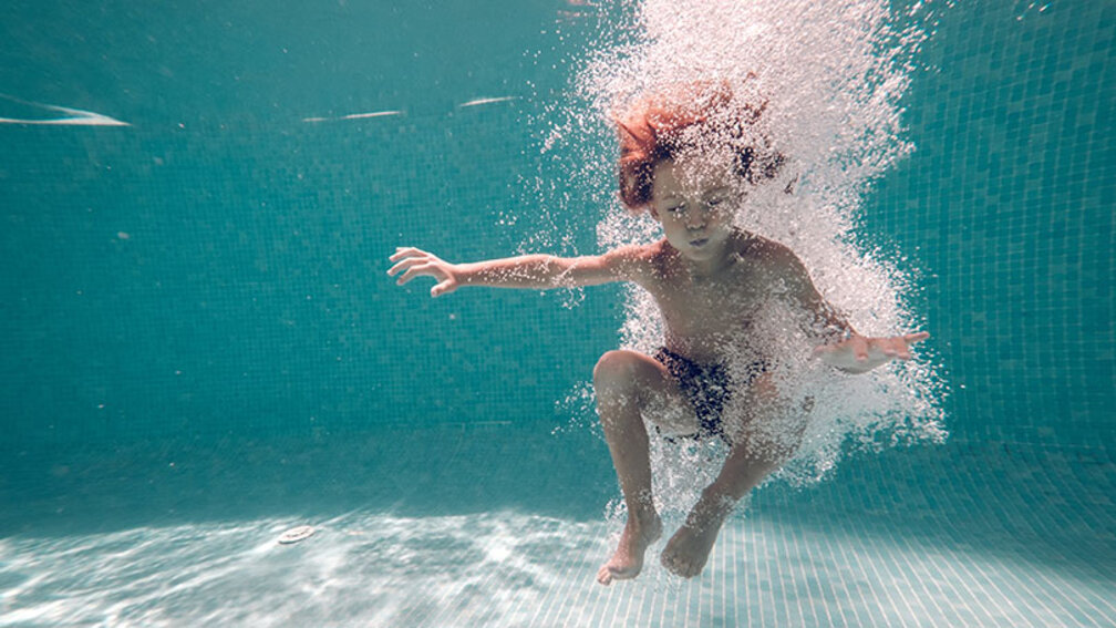 Junge ist ins Wasser gesprungen und taucht unter