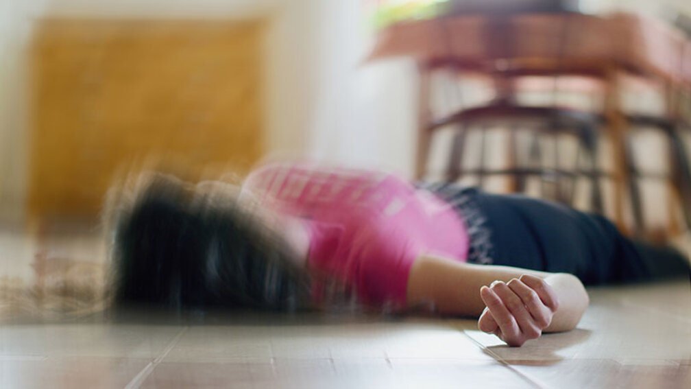 Frau mit Epilepsie liegt ohnmächtig am Boden