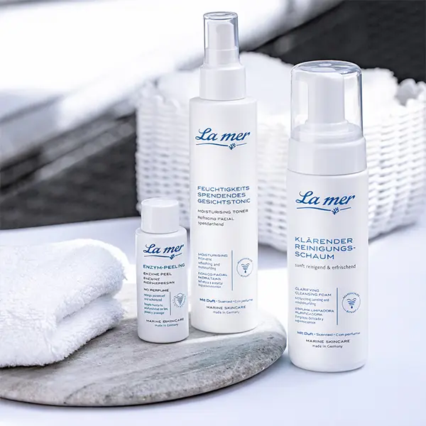 Drei Produkte der Reinigungslinie von La mer im weiß-blauen Verpackungsstil
