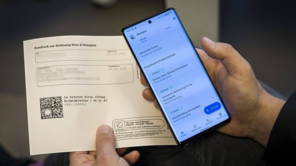 Ausdruck eines E-Rezepts neben Smartphone