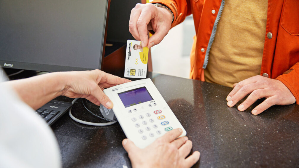 Gesundheitskarte wird in Kartenlesegerät gesteckt