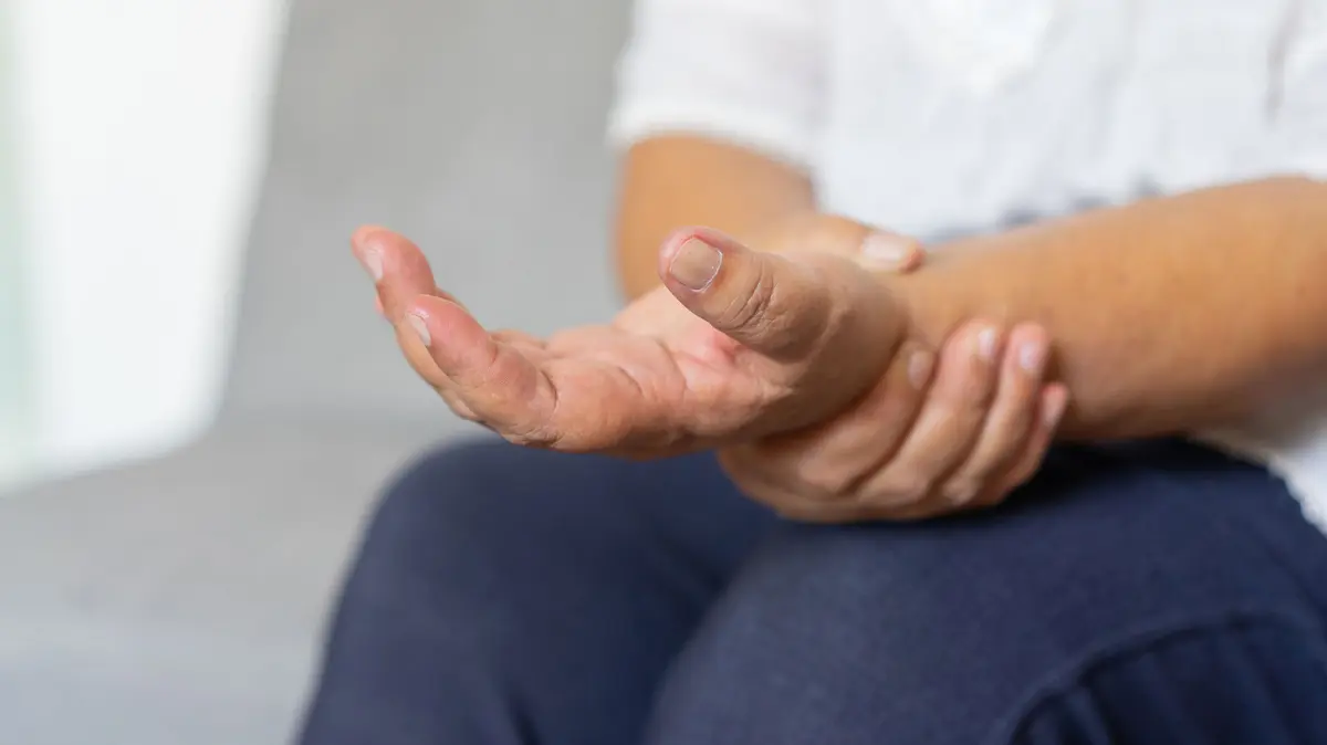 Frau hält ihre Hand fest
