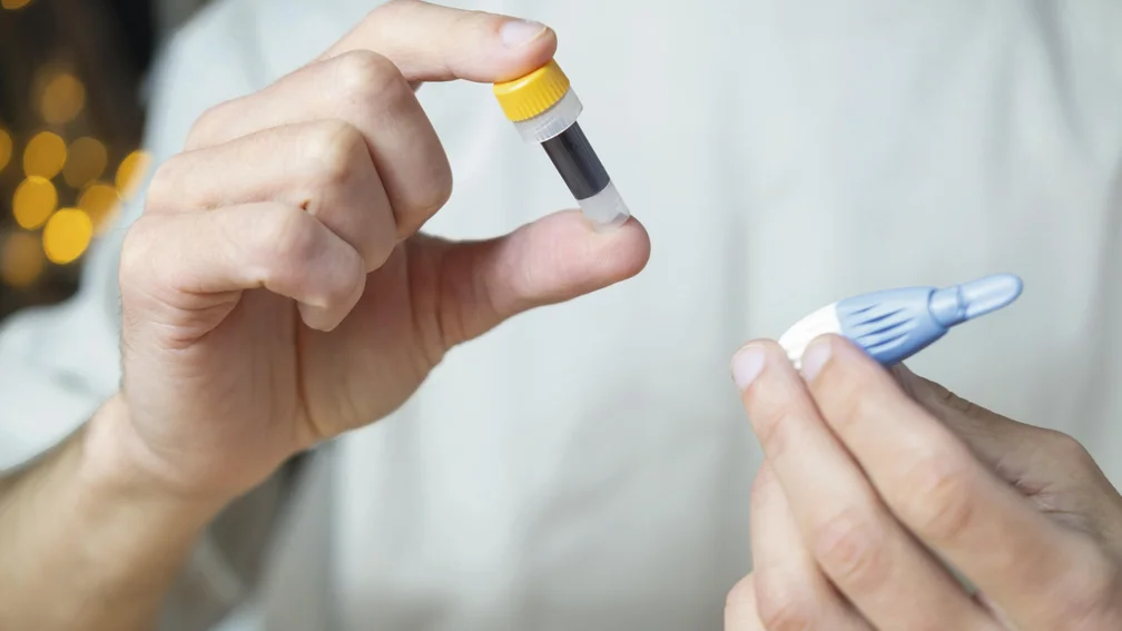 Person hält Blut-Selbsttest in der Hand