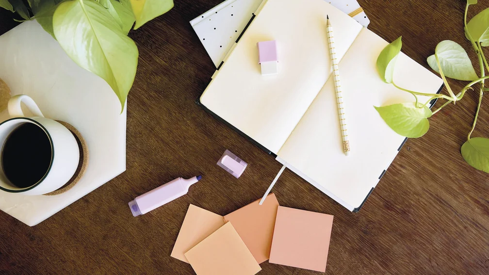 Schreibtisch mit Noizheft, Post-its, Textmarker