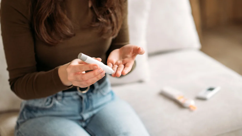 FRau misst ihren Blutzucker mittels Pen und Teststreifen