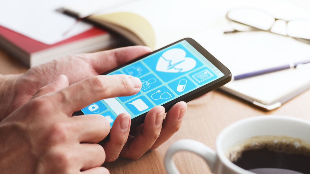 Handy wir in den Händen gehalten, offene App sichtbar