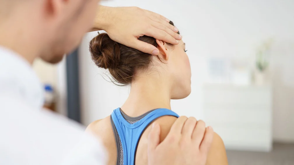 Physiotherapeut behandelt Frau am Nacken