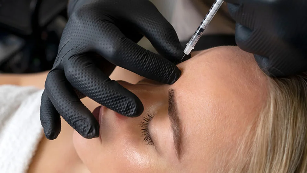 junge Frau erhält Botox-Injektion in Zornesfalte