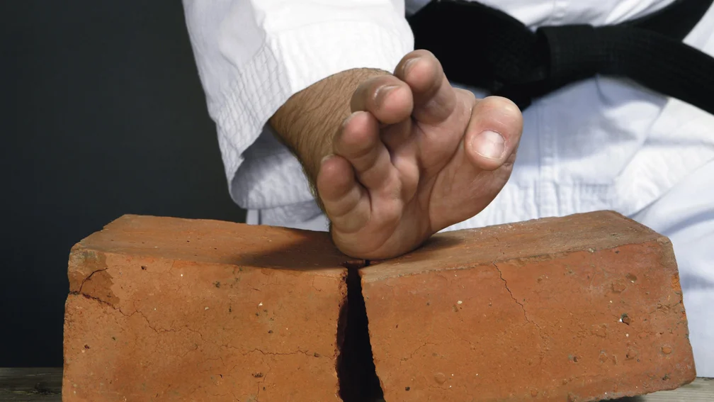 Person teilt einen Backstein mit der Hand