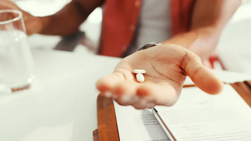 In einer Handfläche liegen zwei weiße Tabletten