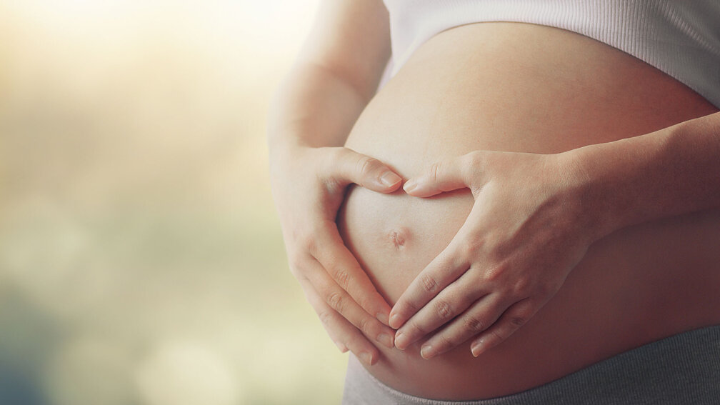 Schwangere Frau hält sich Baby-Bauch