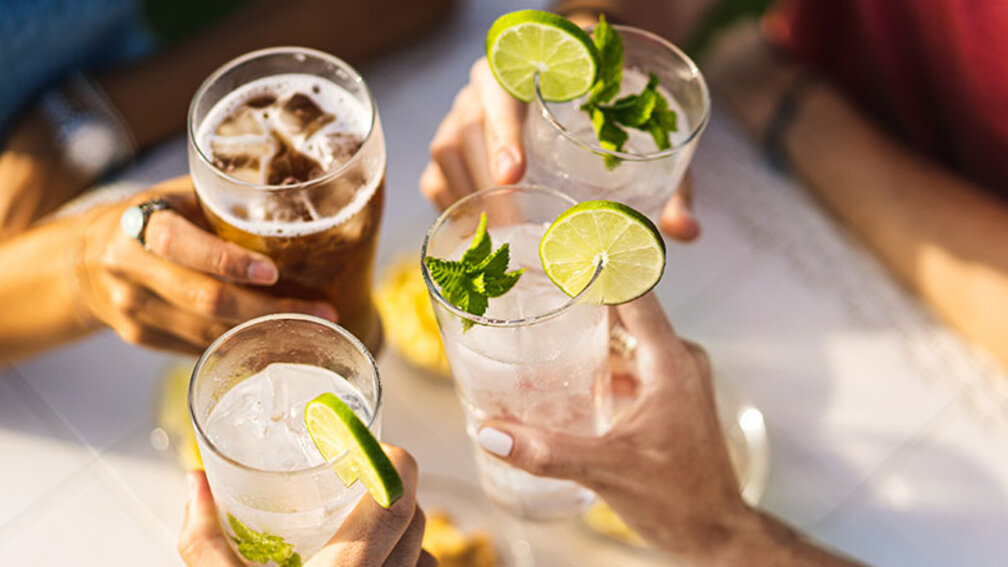 Vier Personen stoßen Gläser mit Limonade an
