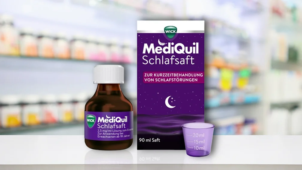 Flasche WickMediQuil neben Packung und Messbecher