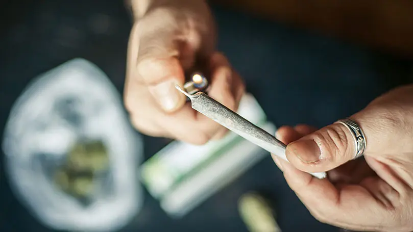 Eine Person zündet einen Joint an