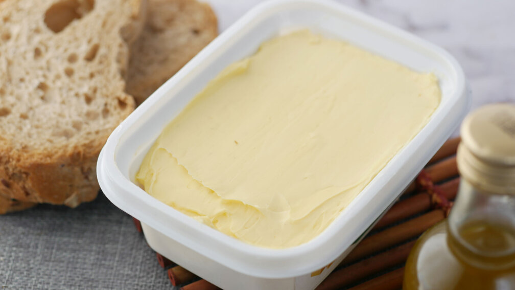 Pott Margarine und Brotscheiben liegen auf einem Tisch