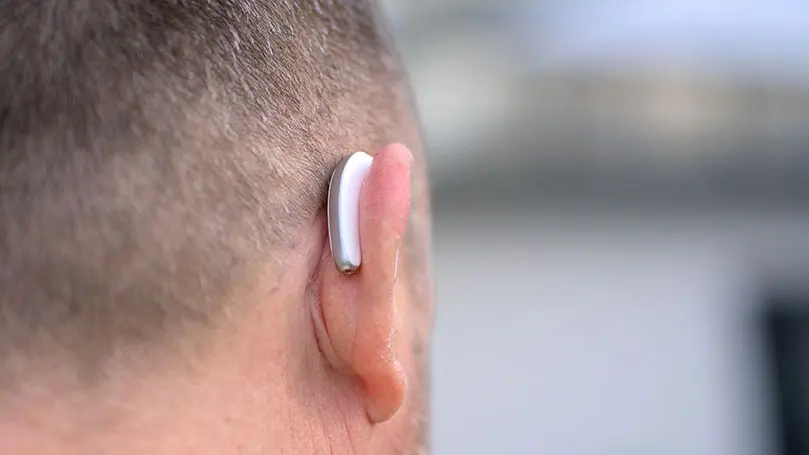 Rückansicht auf das Ohr eines Mannes mit Hörgerät