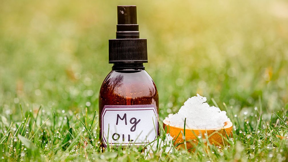 Sprayflasche mit MAgnesiumöl und Schale mit Magnesiumsalz in einer Wiese
