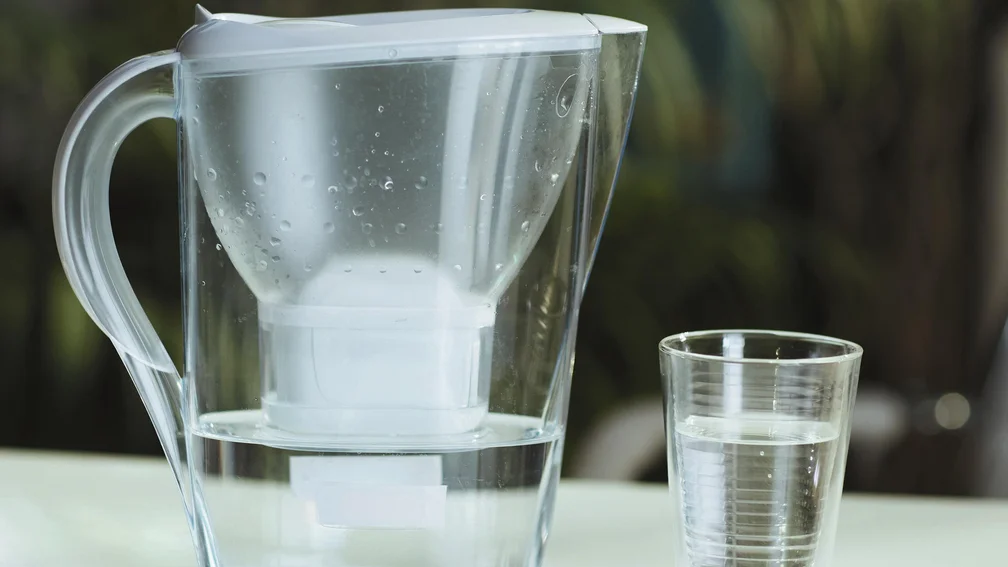 Wasserfilter und ein Glas Wasser daneben
