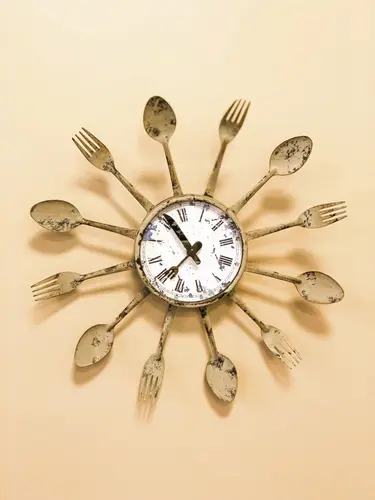 Wanduhr an der ringsum Messer, Gabeln und Löffel befestigt sind 