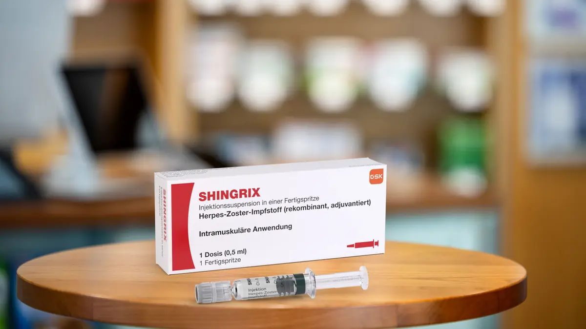 Verpackung und Fertigspritze von Shingrix stehen auf dem HV-Tisch