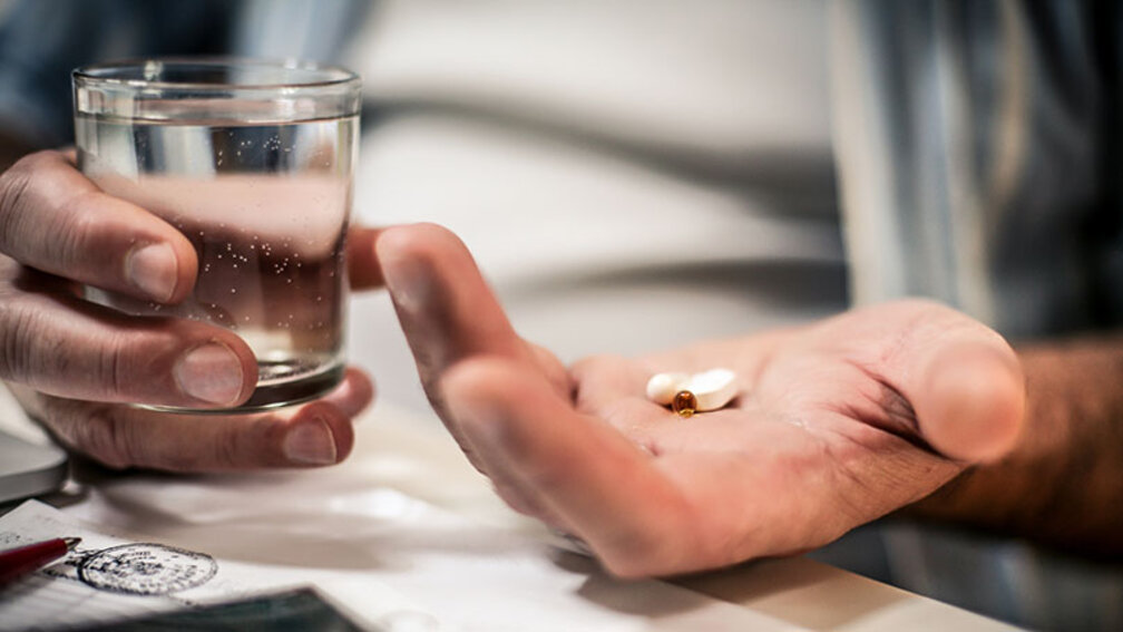 Männliche Hand mit Pillen