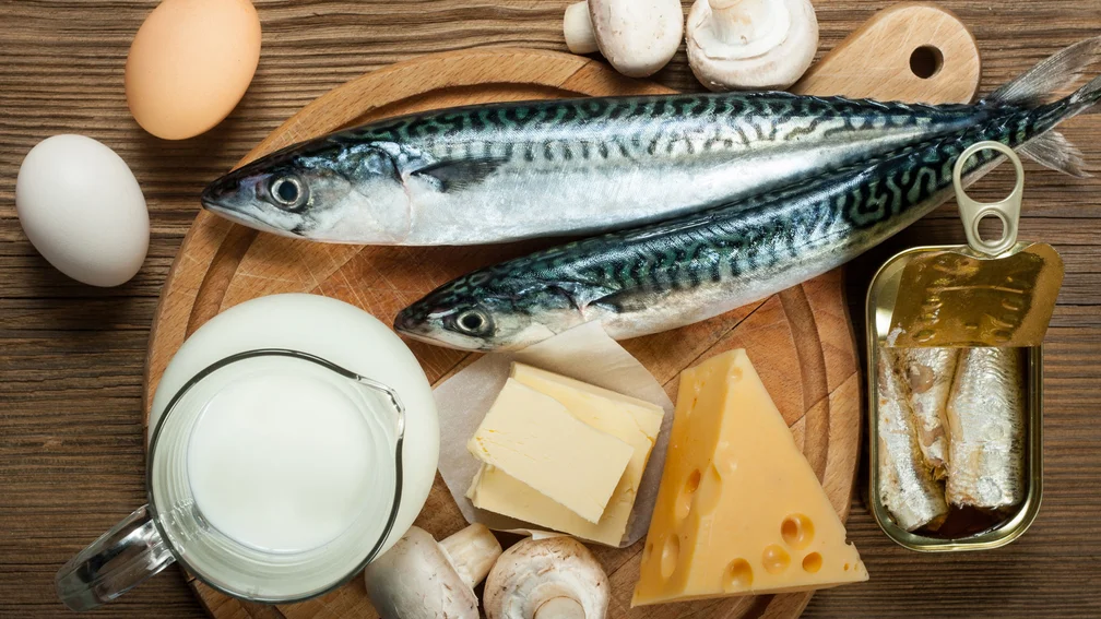 Fisch, Eier, Milch und Käse liegen auf einem Holzbrett