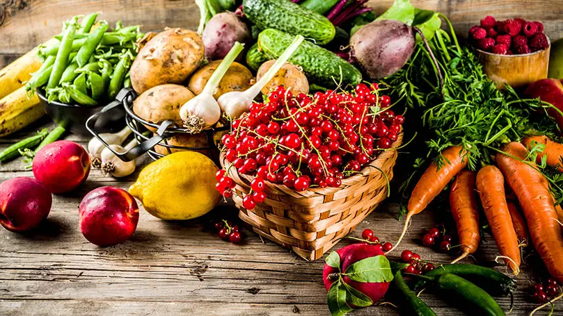 Frisches Gemüse und Obst auf einem Holzuntergrund