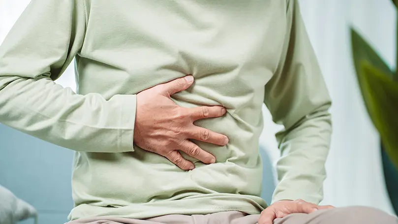Mann hält sich Hand auf den Bauch