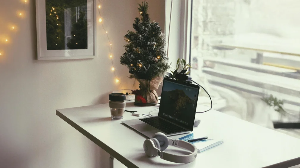 Schreibtisch mit Laptop und einem Mini-Weihnachtsbaum