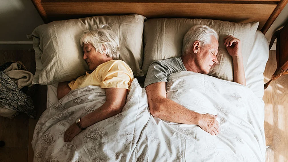 Älteres Ehepaar liegt schlafend im Bett
