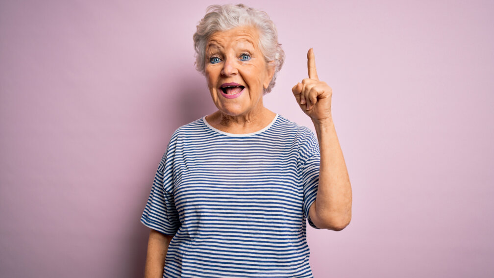 Seniorin hebt mahnend den Zeigefinger