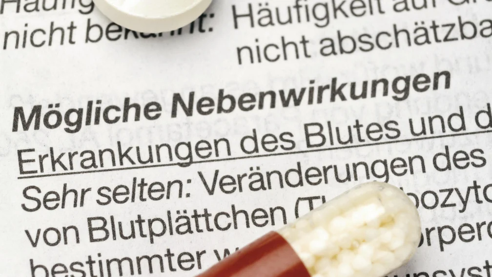 Eine Tablette und eine Kapsel liegen auf einem Beipackzettel